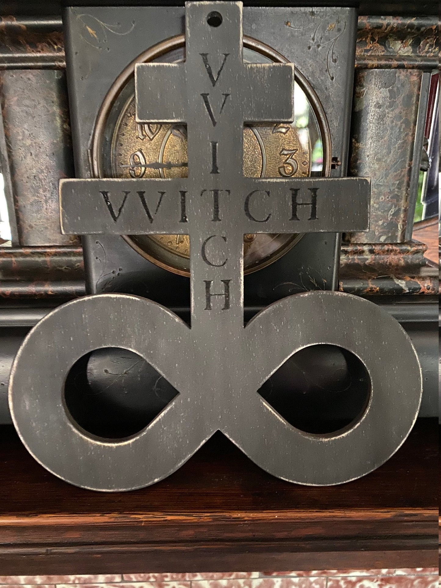 Black on black hanging Brimstone symbol with "VVITCH" engraved.